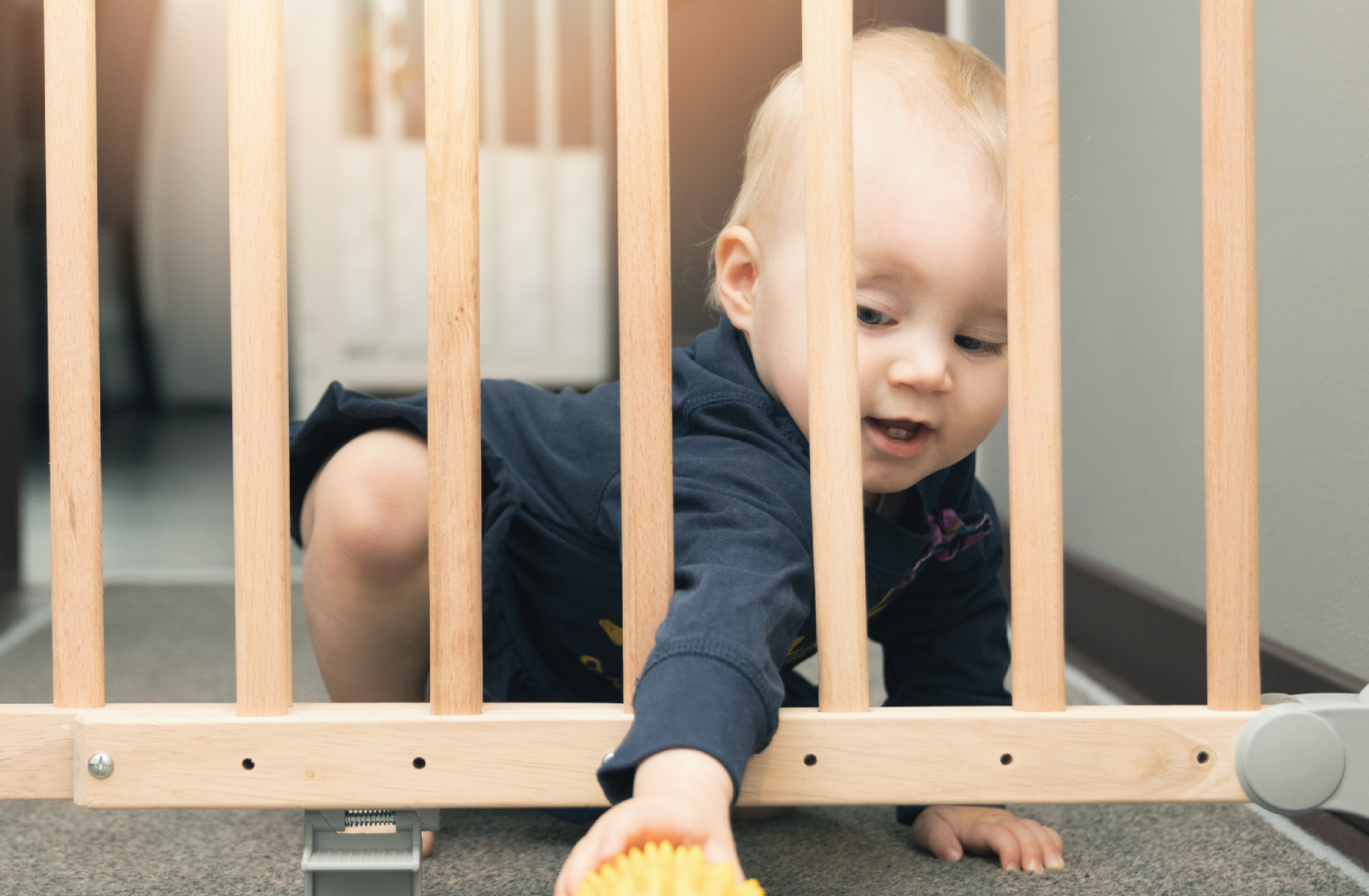 Child reaching through a baby gate