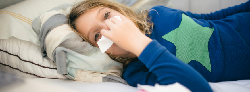 Picture of child who is feeling sick wiping her nose
