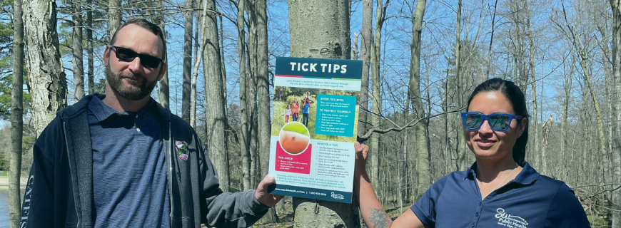 Conservation area authority and health unit staff hang up tick poster