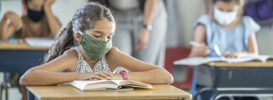 Young girl wearing face mask in school classroom