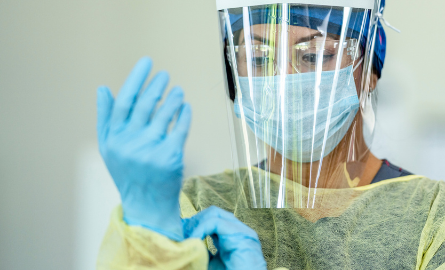 Photo of a health care professional donning gloves.
