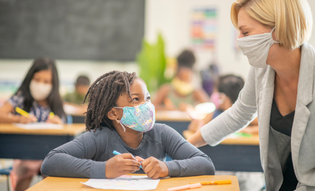 Picture of a student and a teacher wearing face masks