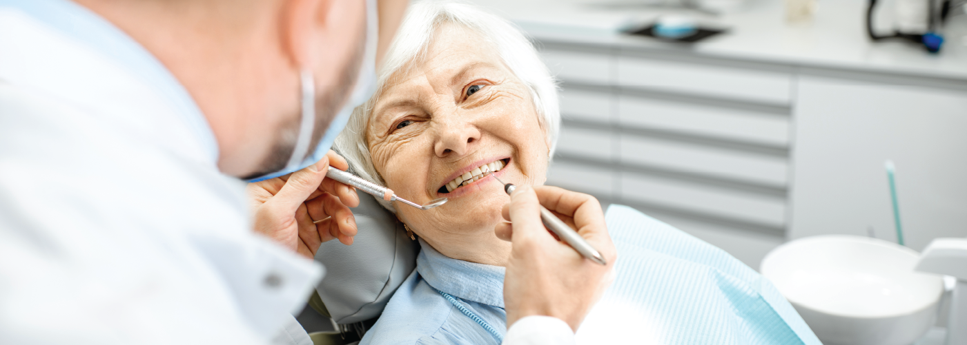 senior woman sitting in a dental chair smiling