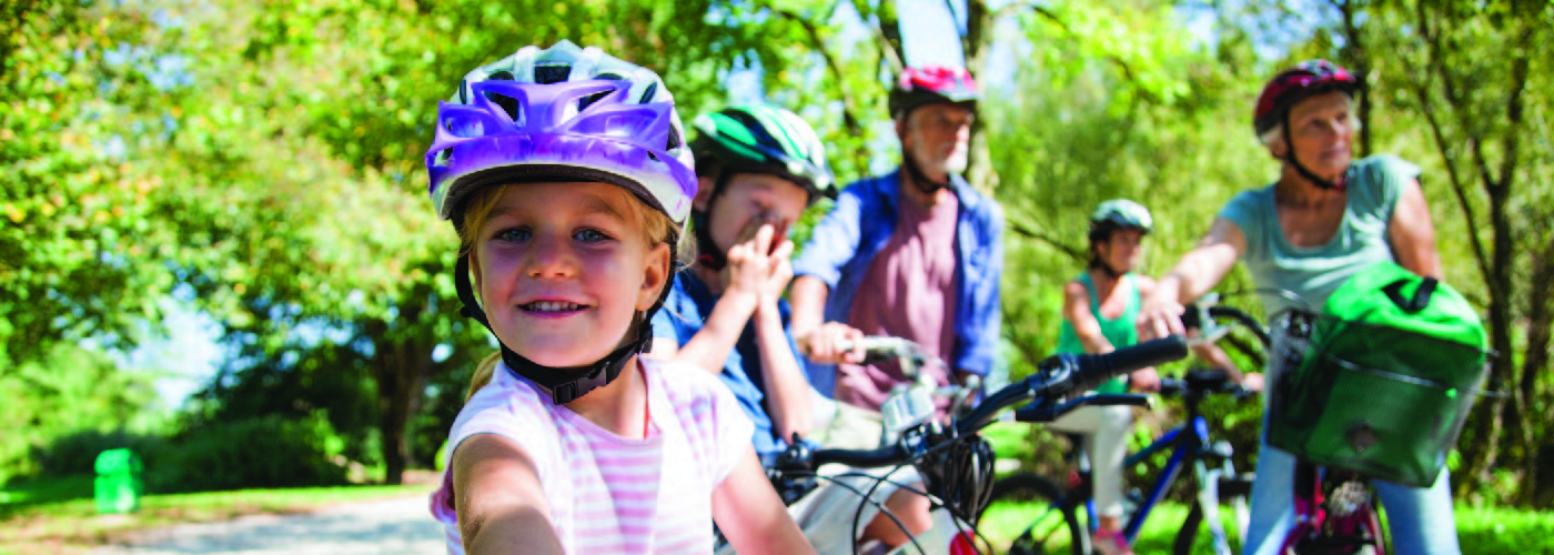Family biking outdoors wearing helmets