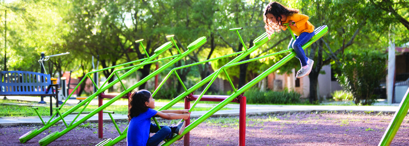 Two young girls playing on playground equipment