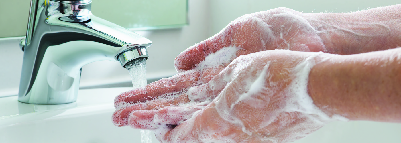 person washing hands with soap and water