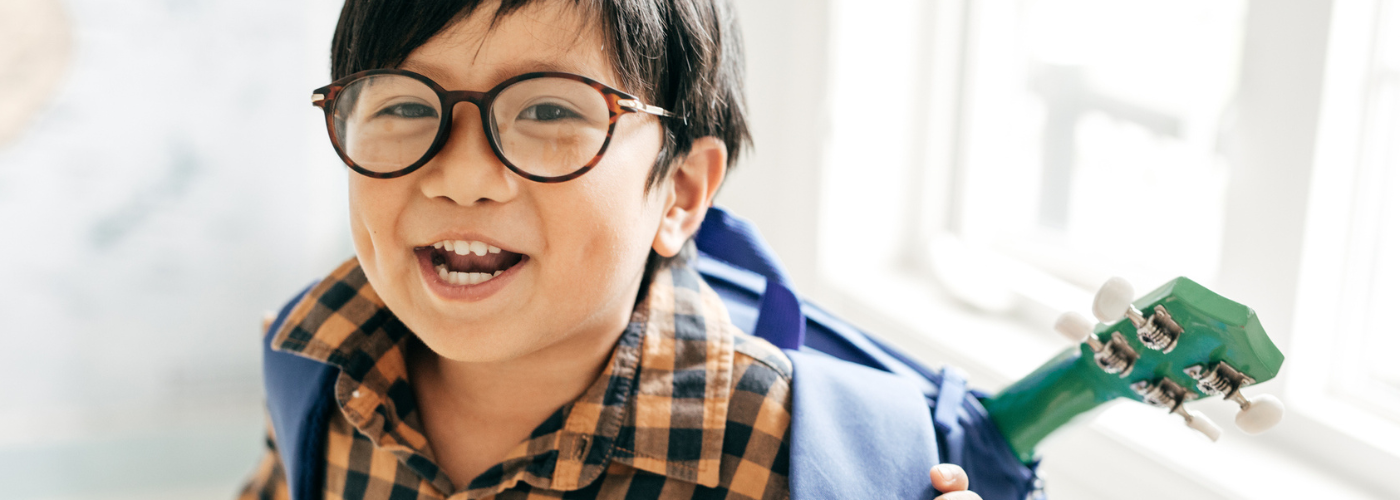 young boy wearing glasses while getting vision screening