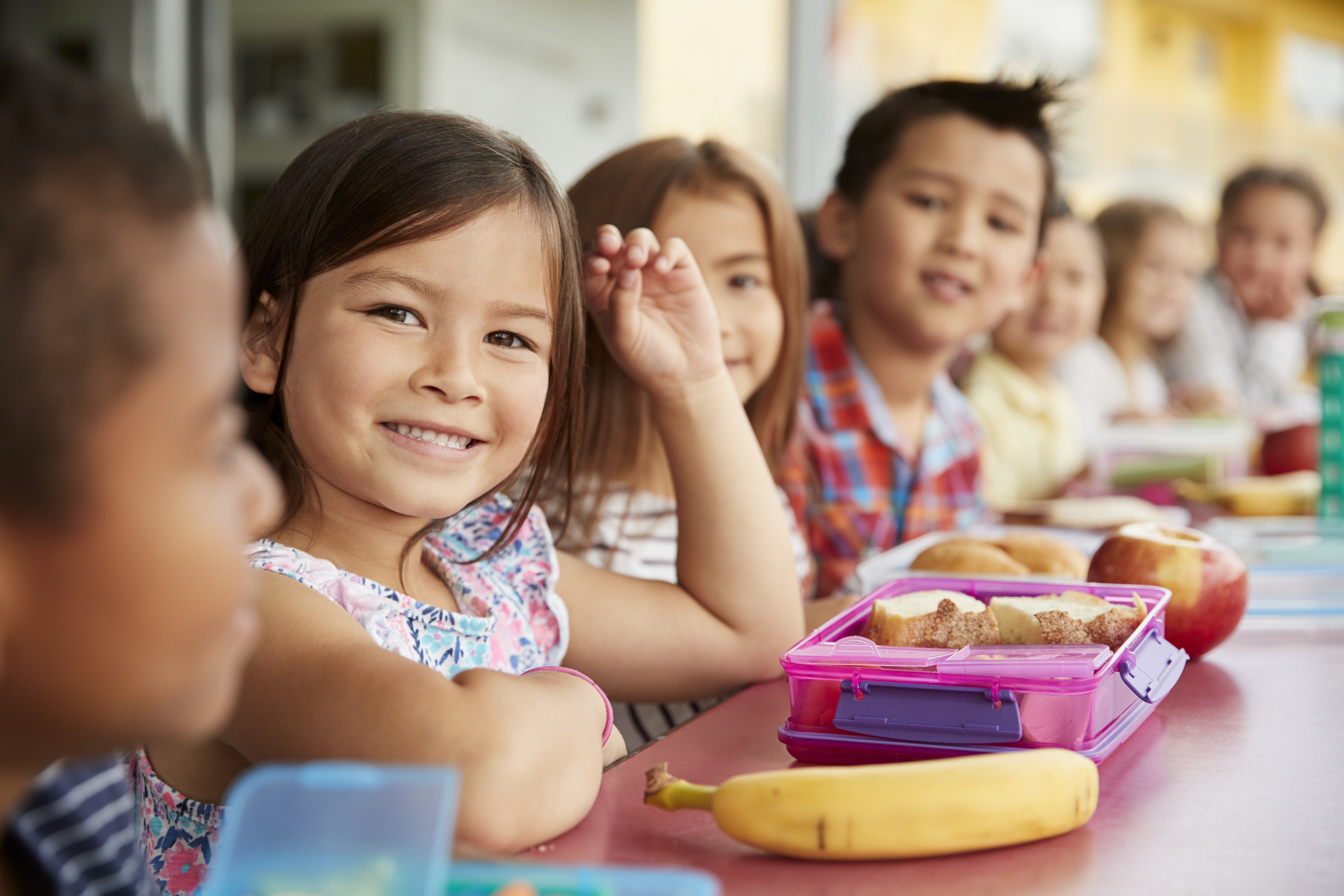 Group of smiling children eating their lunch together