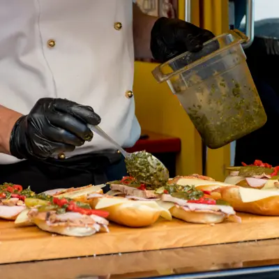 Food service worker wearing gloves and uniform prepares sandwiches