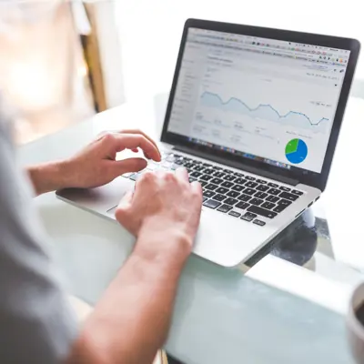 Close-up of a laptop screen displaying graphs and a pie chart for data analysis