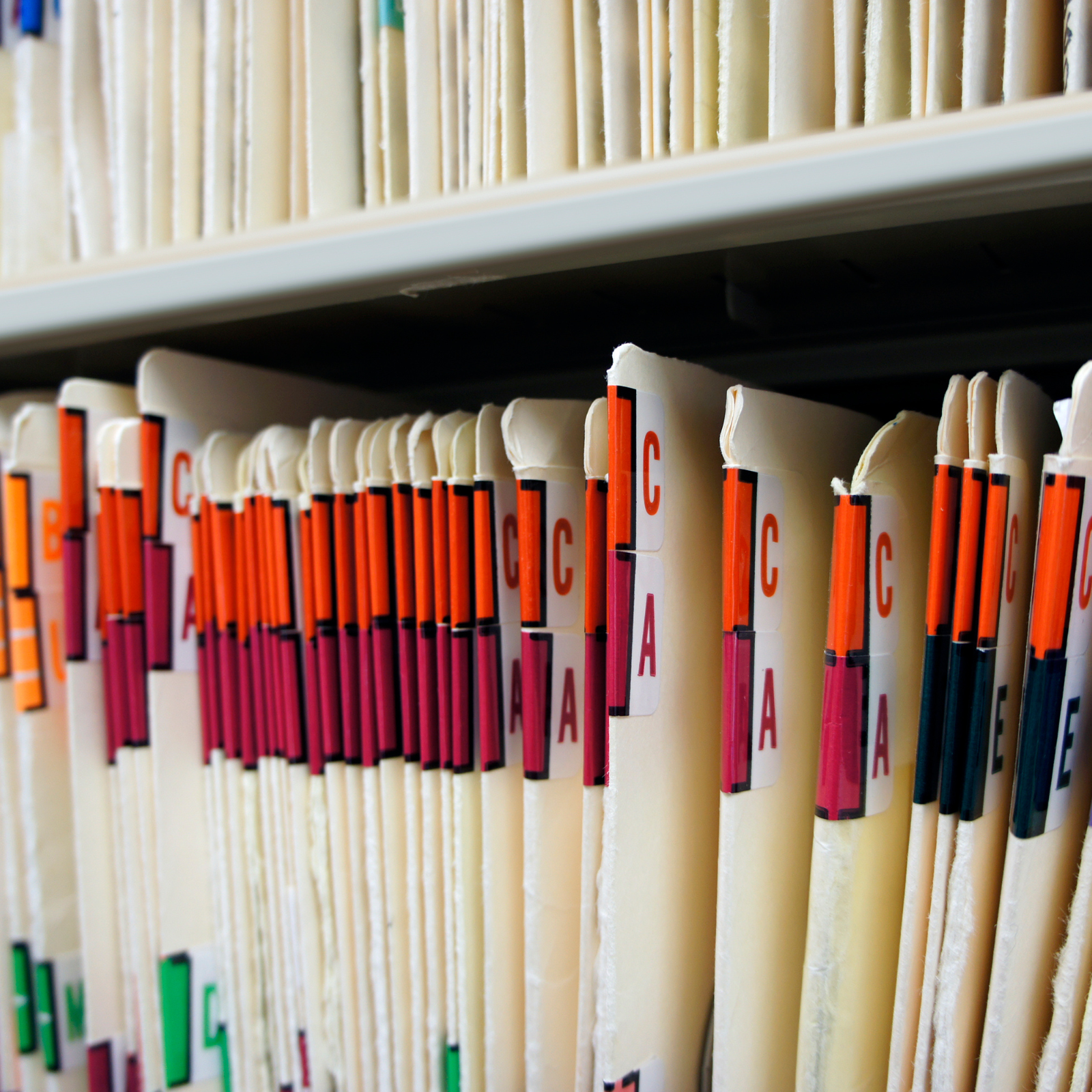 Close-up view of organized paper files with coloured tabs