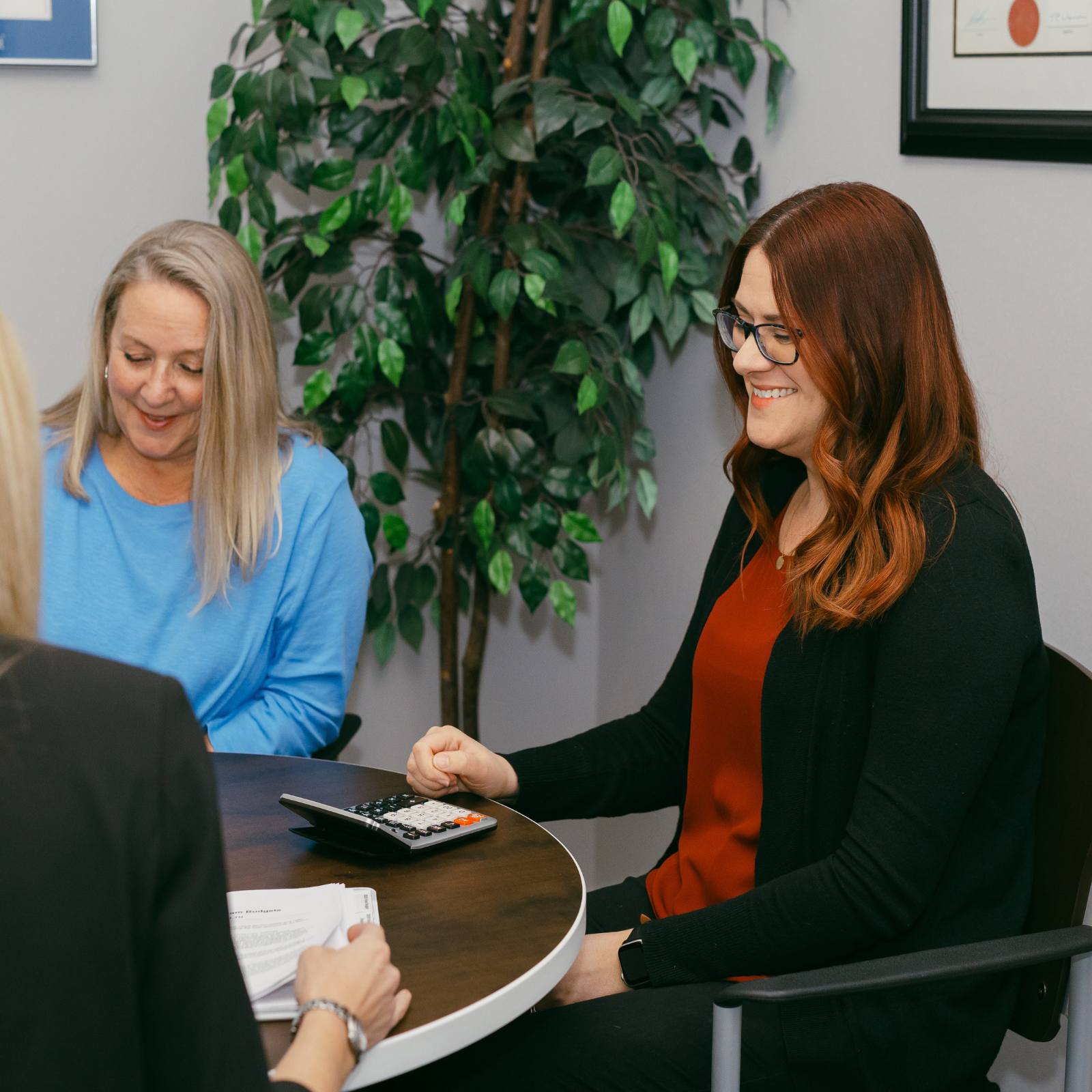 Two women smiling during a workplace meeting at a round table
