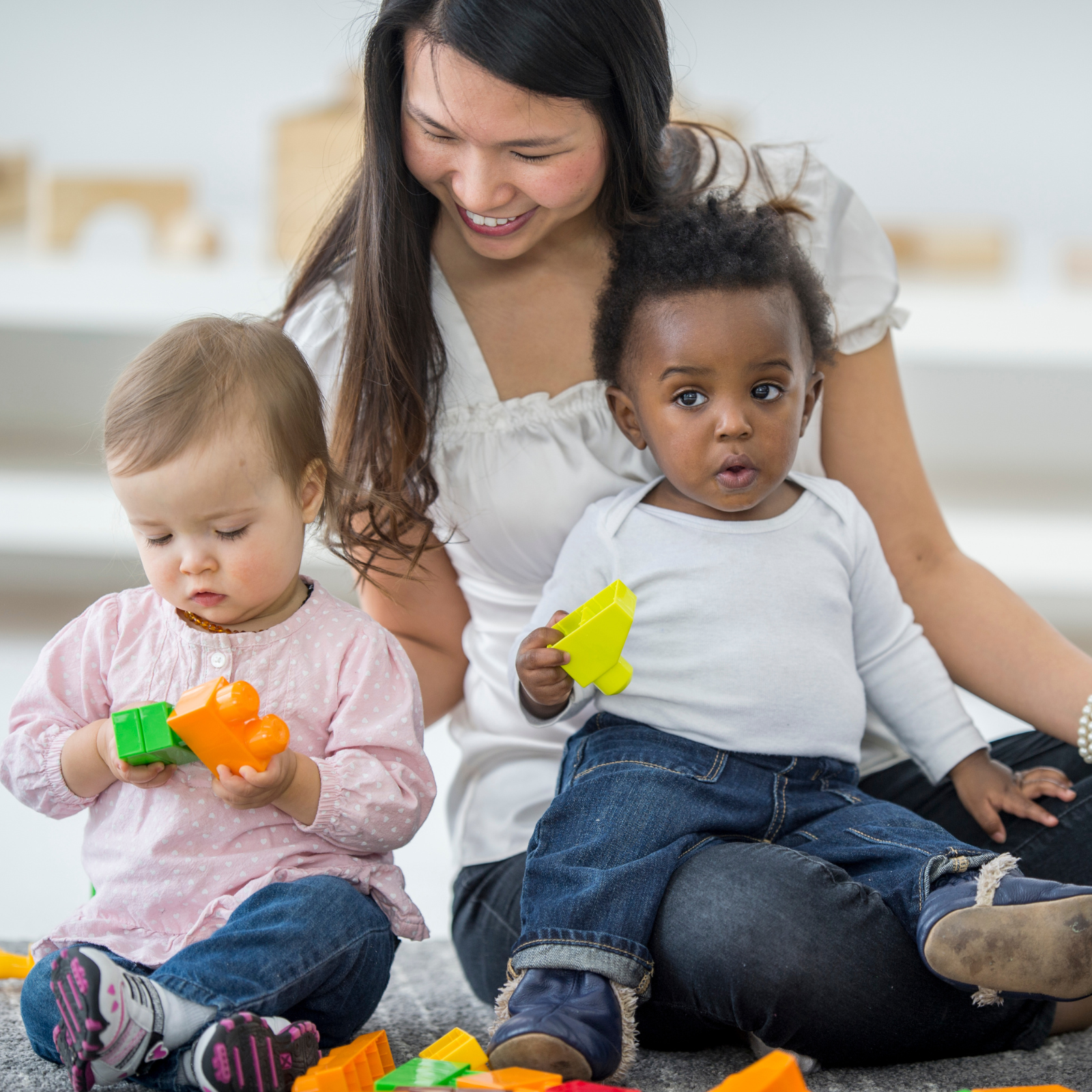 Woman playing with two babies
