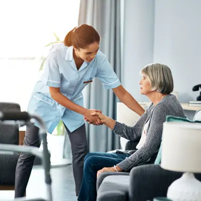 Nurse assisting an elderly woman in a nursing home setting