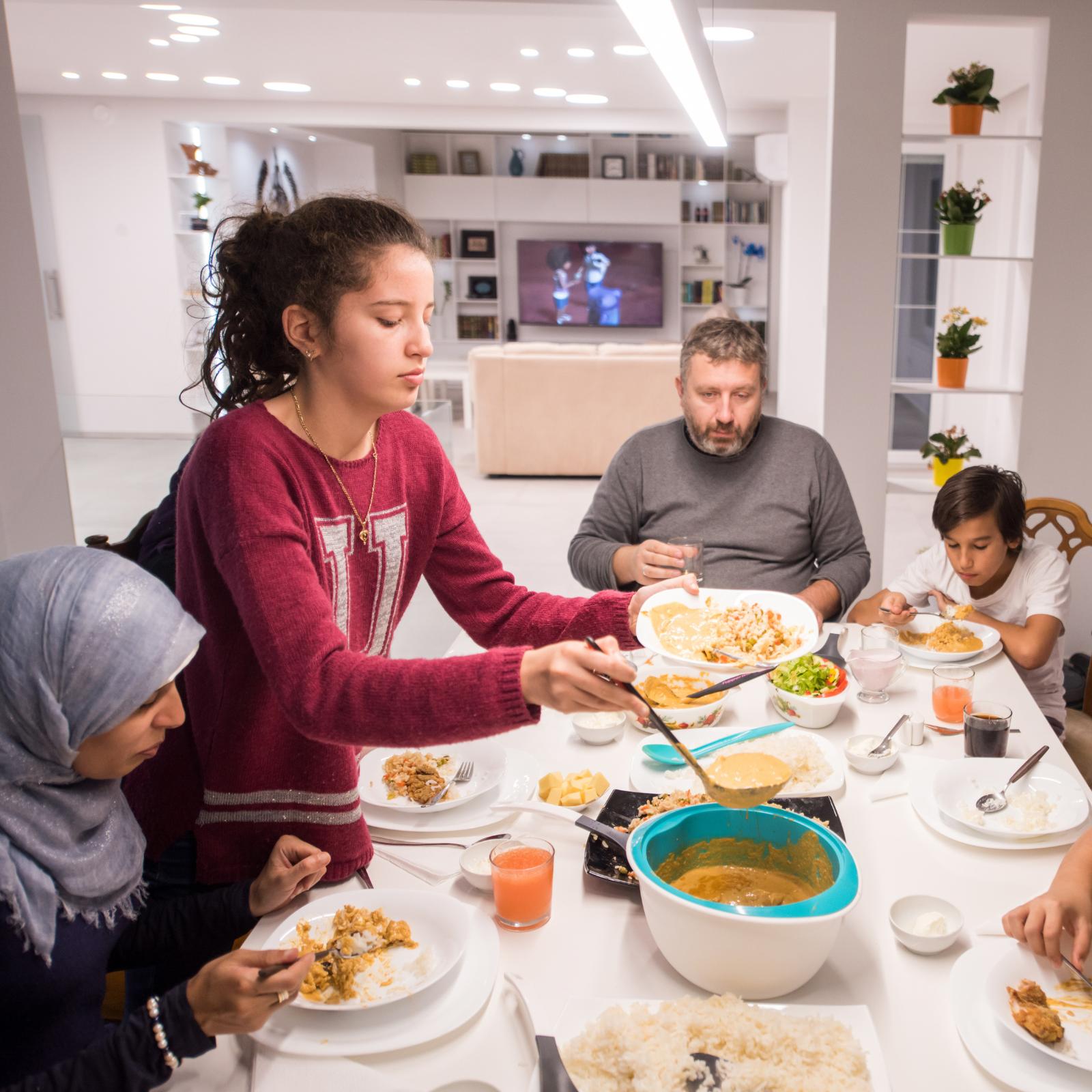 Family gathered around a dining table sharing a meal together