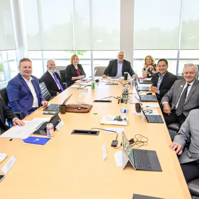 Board members seated around a large conference table during a meeting